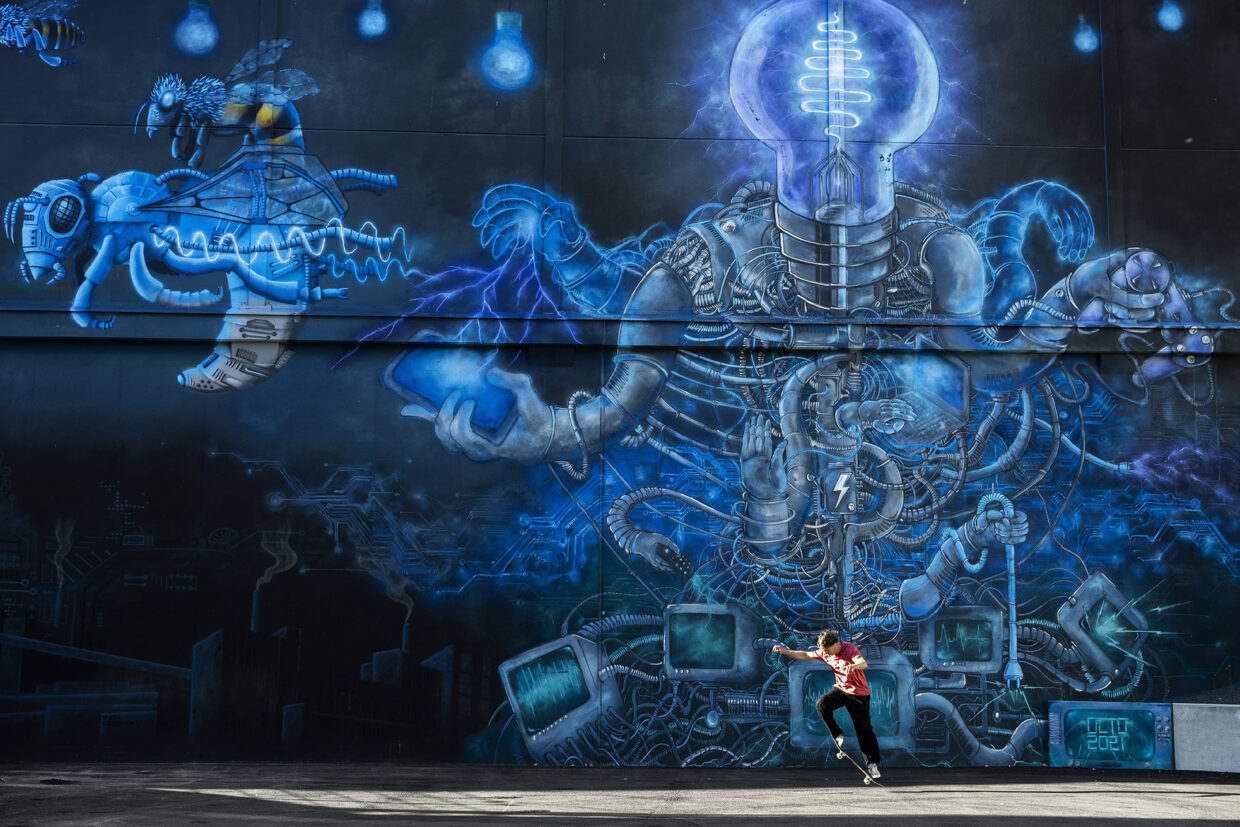 Mies skeittaa muraalin edessä