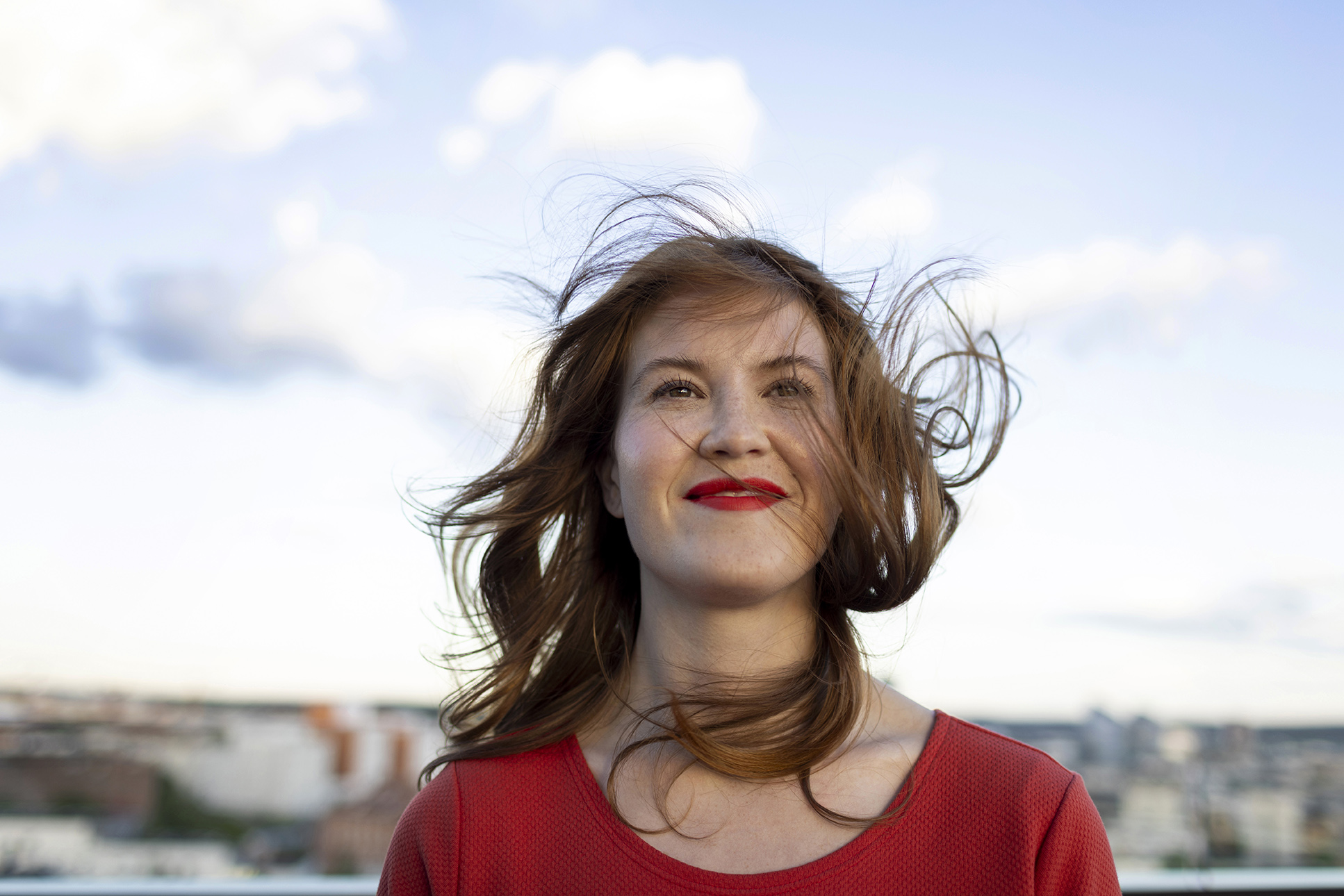 Nainen, jonka hiuksia tuuli hulmuttaa