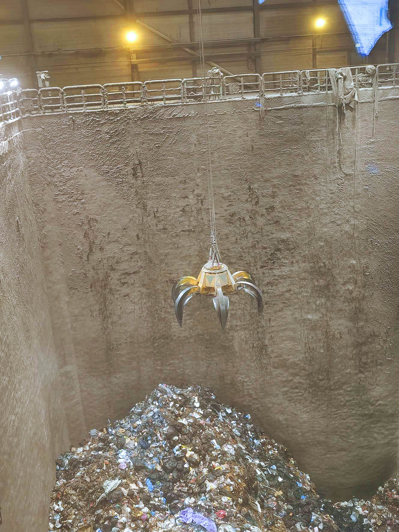 Koura nostaa jätteitä Tammervoiman hyötyvoimalaitoksella.